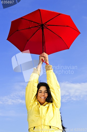 Image of Beautiful young woman in raincoat with umbrella