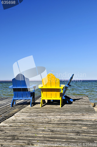 Image of Chairs on wooden dock at lake
