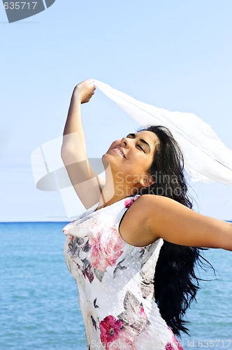 Image of Beautiful young woman at beach with white scarf