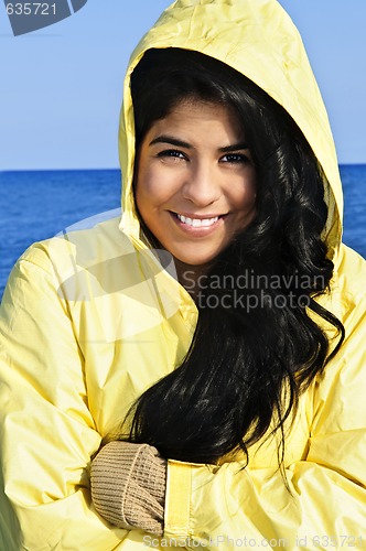 Image of Beautiful young woman in raincoat