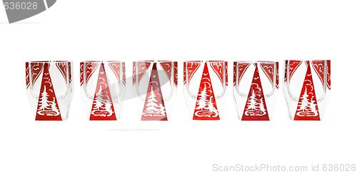 Image of Row of red crystal liqueur glasses with cut fir-trees isolated