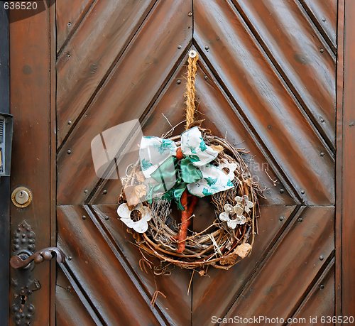 Image of Dry old wreath on brown wooden door