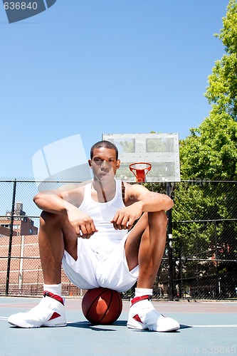 Image of Basketball player sitting on ball