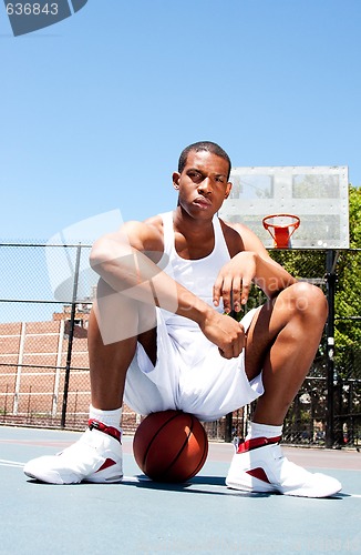 Image of Basketball player sitting on ball