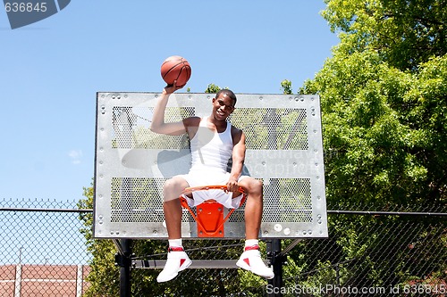 Image of Champion basketball player sitting in hoop