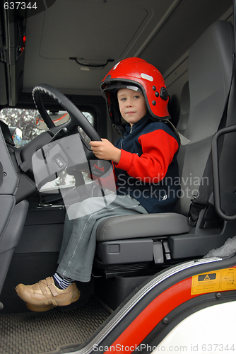 Image of boy is sitting in a fire truck