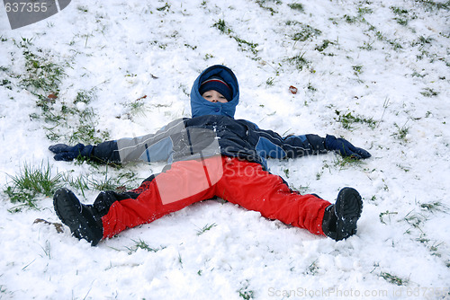 Image of Young boy sit on snow.