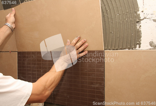 Image of laying ceramic tile on wall