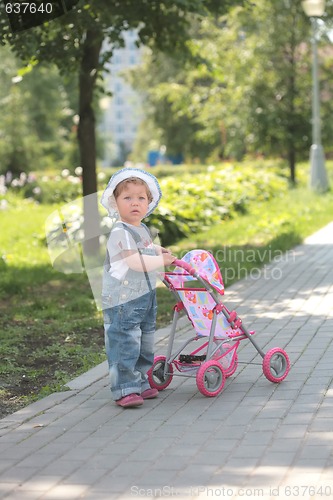 Image of little girl walks with toy sidercar