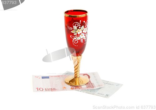 Image of Red wine glass  with golden stem on euro bills isolated