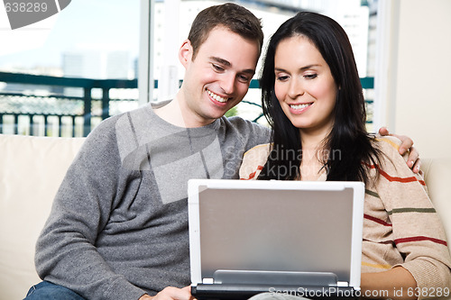 Image of Happy couple browsing internet at home