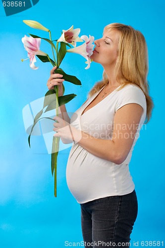 Image of happy pregnant woman with flower