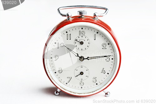 Image of Old red analog alarm clock.