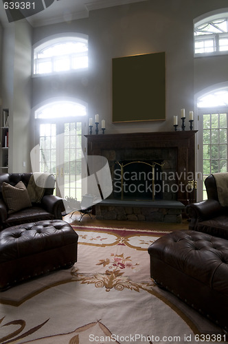 Image of large living room with leather chairs and fireplace