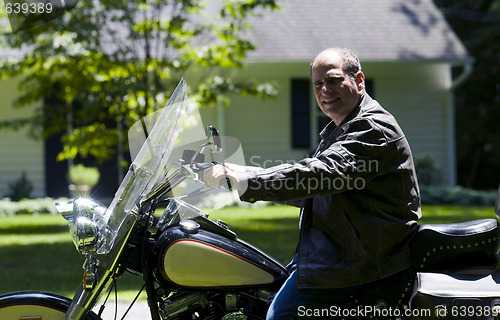 Image of middle age man on motorcycle with leather jacket
