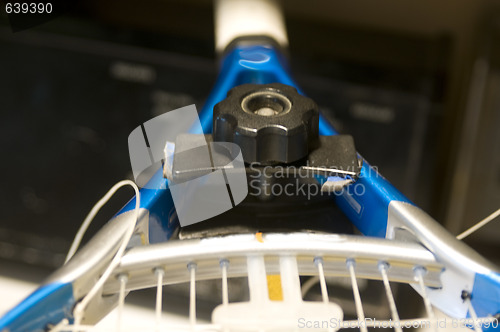 Image of tennis racquet restring job on machine
