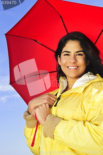 Image of Beautiful young woman in raincoat with umbrella