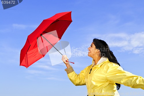 Image of Beautiful young woman in raincoat with umbrella