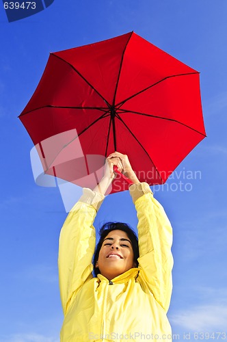 Image of Beautiful young woman in raincoat with umbrella