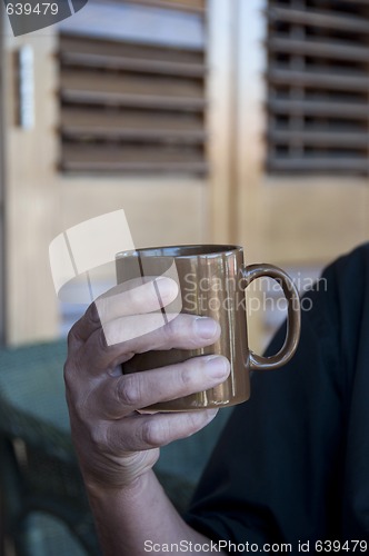 Image of Man holding a hot drink in a mug