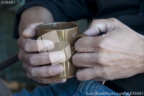 Image of Man holding a hot drink in a mug