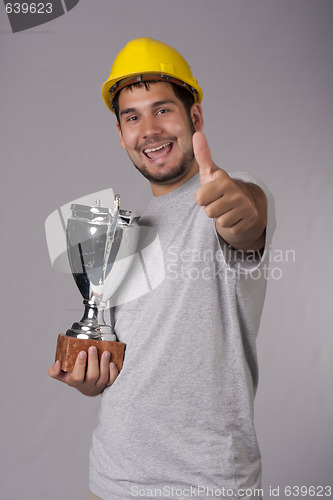 Image of Smiling worker with big silver cup and thumb up