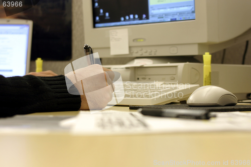 Image of Signing a Document on a Messy Desk