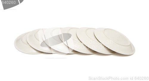 Image of Stack of plain beige plates tiled upside down isolated