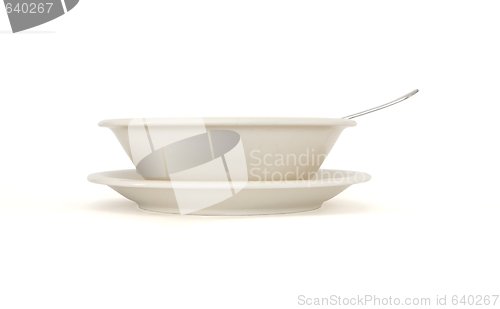 Image of Plain beige soup plate with spoon and saucer side view isolated