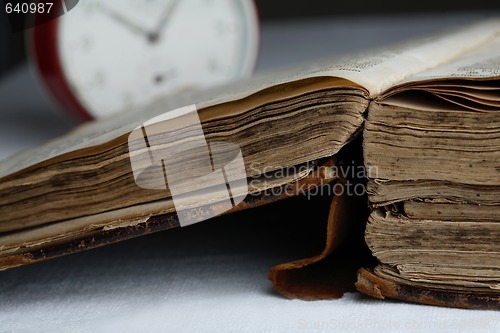 Image of Old book and analog clock.