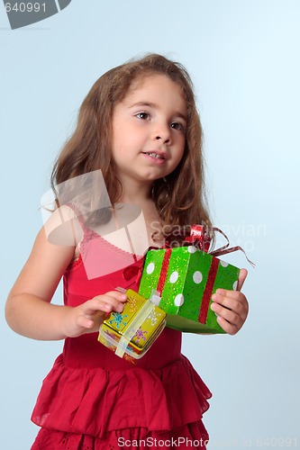 Image of Little girl holding Christmas presents