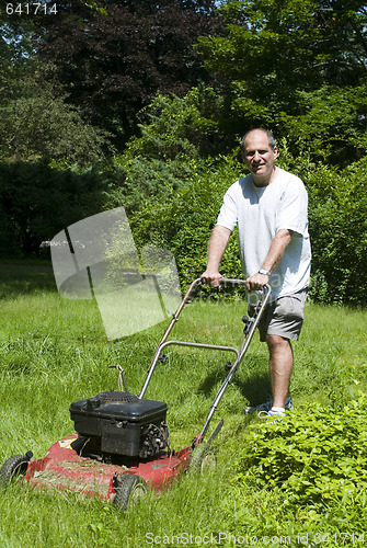 Image of man cutting grass at suburban house