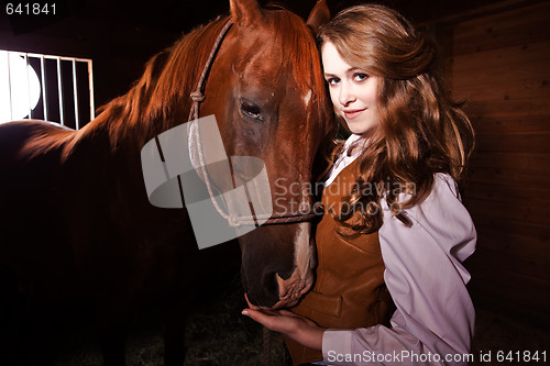 Image of Beautiful caucasian cowgirl with a horse