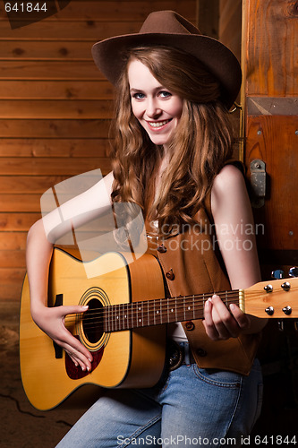 Image of Beautiful caucasian cowgirl with guitar