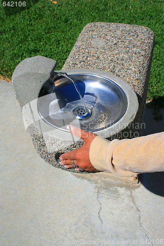 Image of Hand Pushing Water Fountain