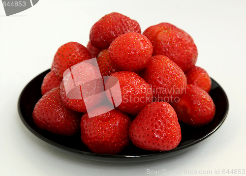 Image of Ripe berries of a strawberry on black saucer