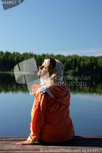 Image of The girl meets morning on the shore of the river