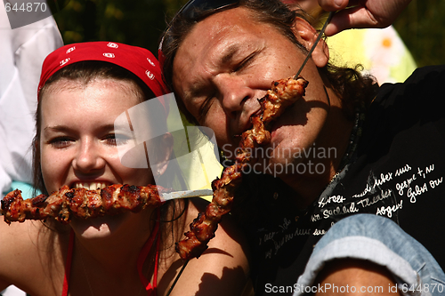 Image of Man and girl eat a shish kebab