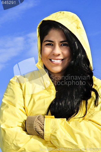 Image of Beautiful young woman in raincoat