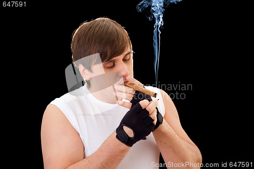 Image of Young man sets fire to a cigar