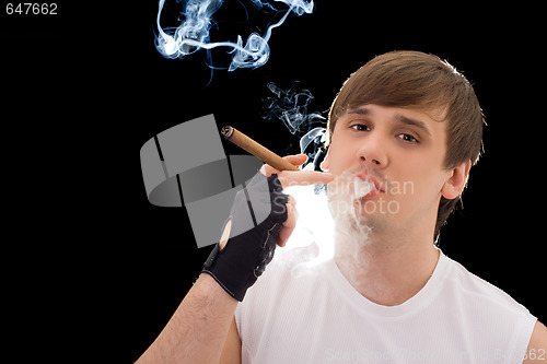 Image of Young man smoking a cigar. Isolated on black