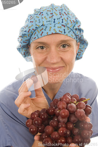 Image of nurse promoting healthy diet with fresh fruit grapes while weari