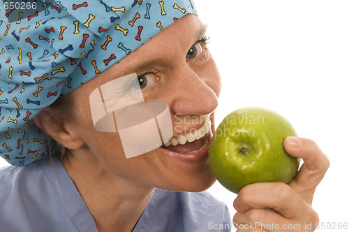 Image of smiling happy nurse doctor eating green apple