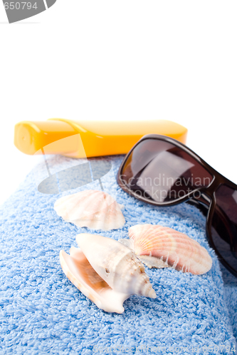 Image of towel, shells, sunglasses and lotion