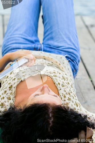 Image of woman lying with book