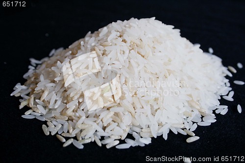 Image of Pile of uncooked rice on black background