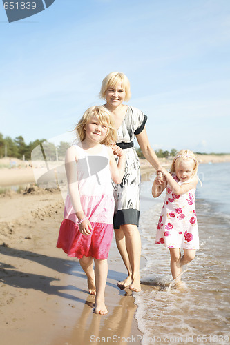 Image of Mother and daughters at beach.