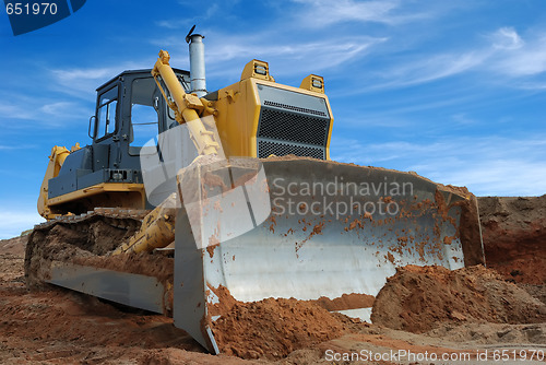 Image of Close-up view of heavy bulldozer standing in sandpit