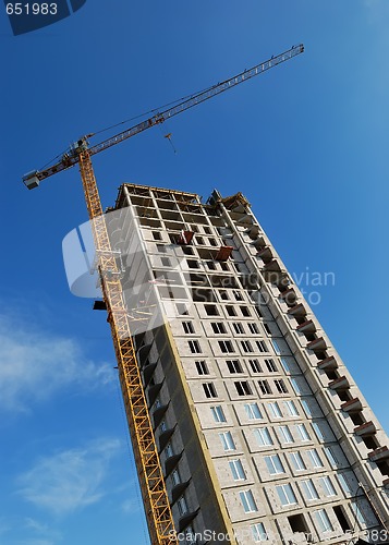 Image of Yellow tower crane at multistory building