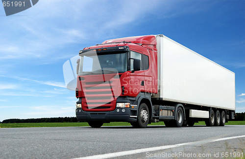 Image of red lorry with white trailer over blue sky